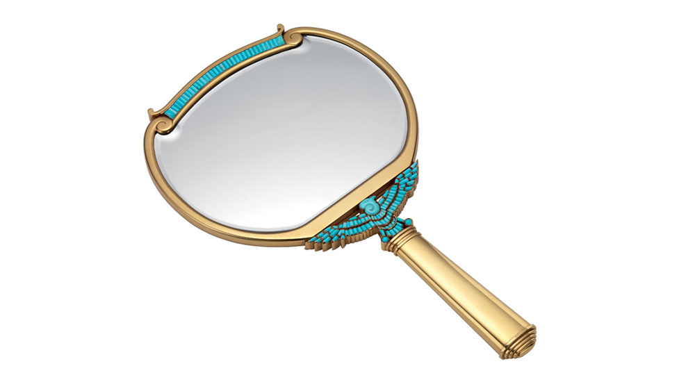 Gold hand mirror decorated with an Egyptian inspired raptor set with calibrated cut turquoise, 1962. Created at the time when Elizabeth Taylor was enacting Cleopatra, the mirror was probably given her as a gift by the production. In the former collection of Elizabeth Taylor. Bulgari Heritage Collection.